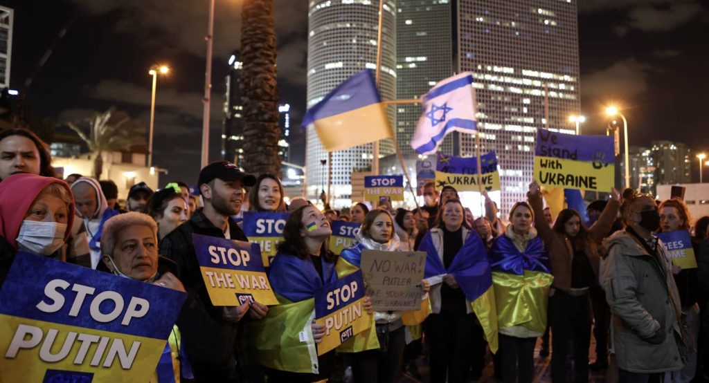 Protestors hold signs at a demonstration against the Russian military invasion into Ukraine, in Tel Aviv, Israel. Photo credit: REUTERS